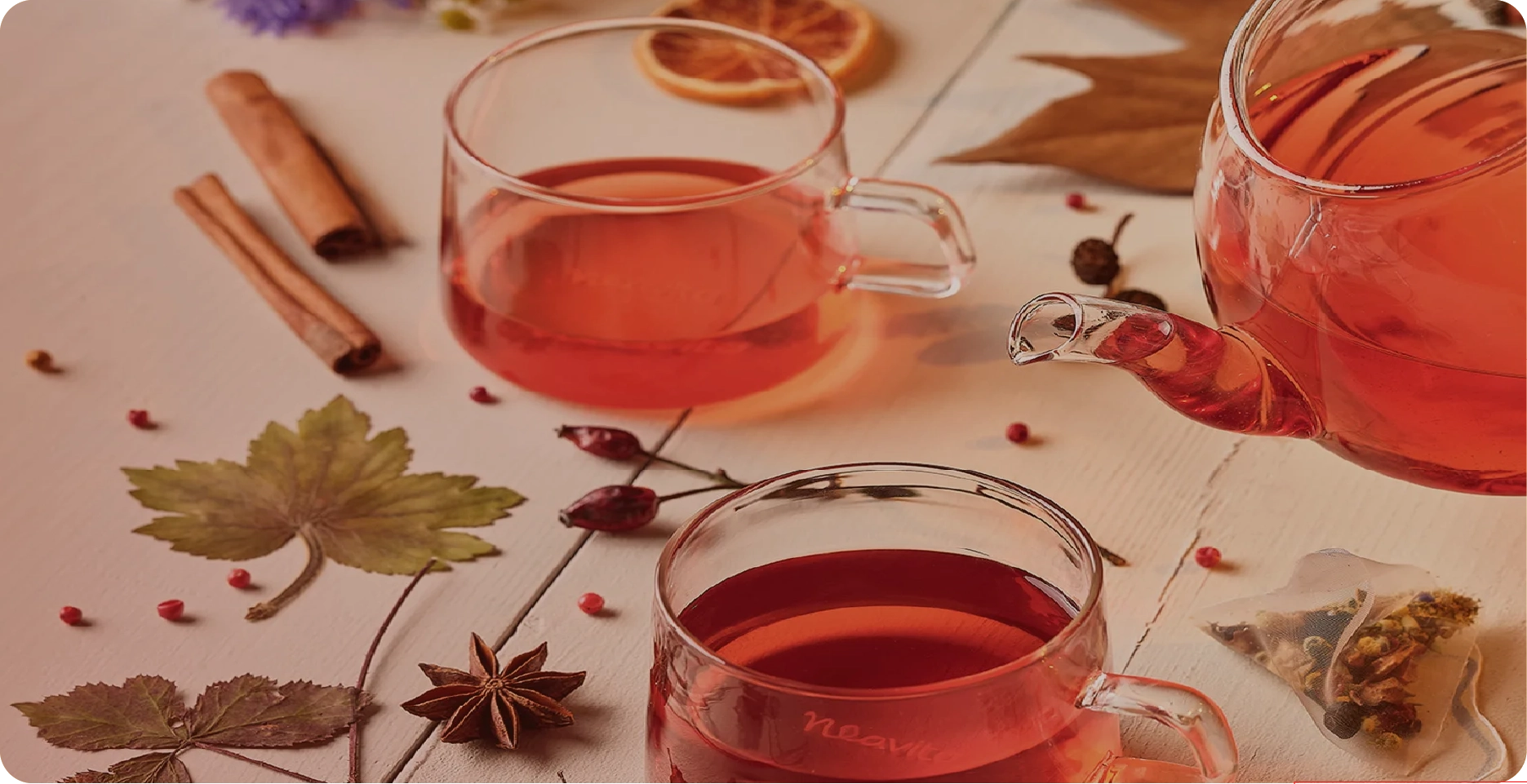 Warm tisane tea infused in glass teapots with cinnamon and dried botanicals